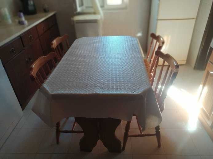 Mesa de cozinha com quatro cadeiras.