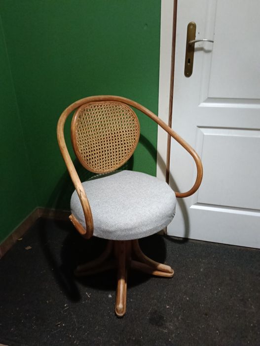 stary fotel obrotowy z oparciem rattanowym