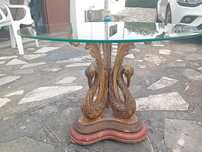 Mesa de vidro com cisnes de madeira