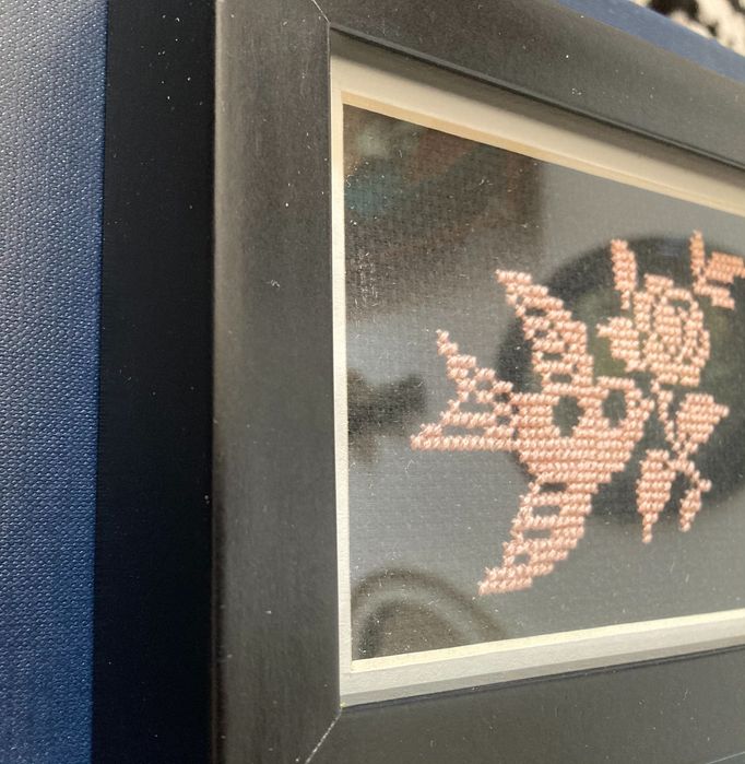 Haft krzyżykowy, ptak z kwiatem, w ramce