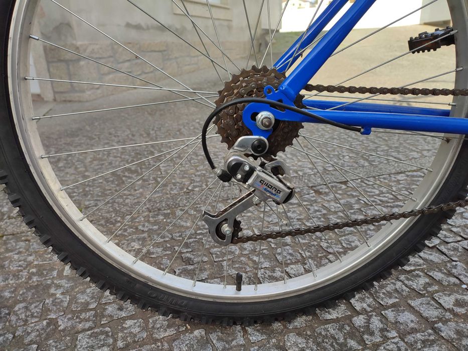 Bicicleta de montanha azul com mudanças e travões Shimano
