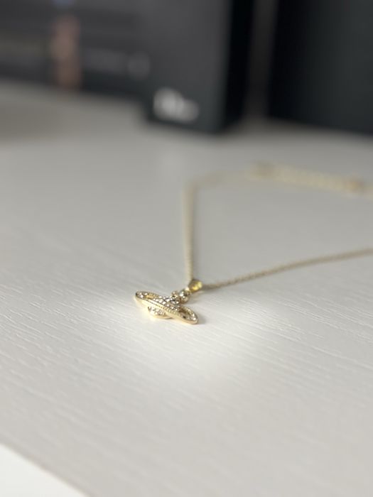 Elegancki naszyjnik w kolorze zlotym  — widoczny wisior, vintage vibe