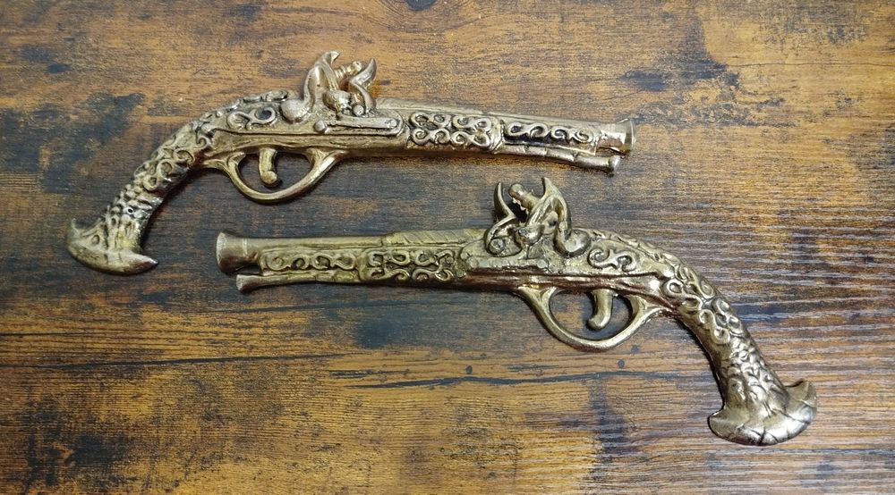 Dwa mosiądzowane pistolety, atrapy.