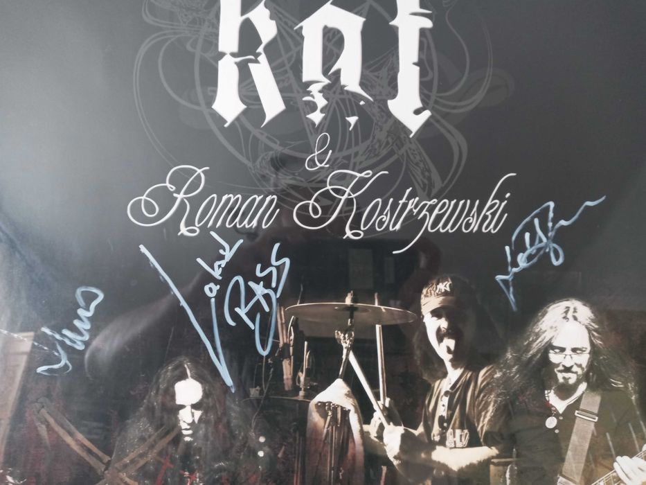 Plakat grupy KAT z autografami grupy w ramie.