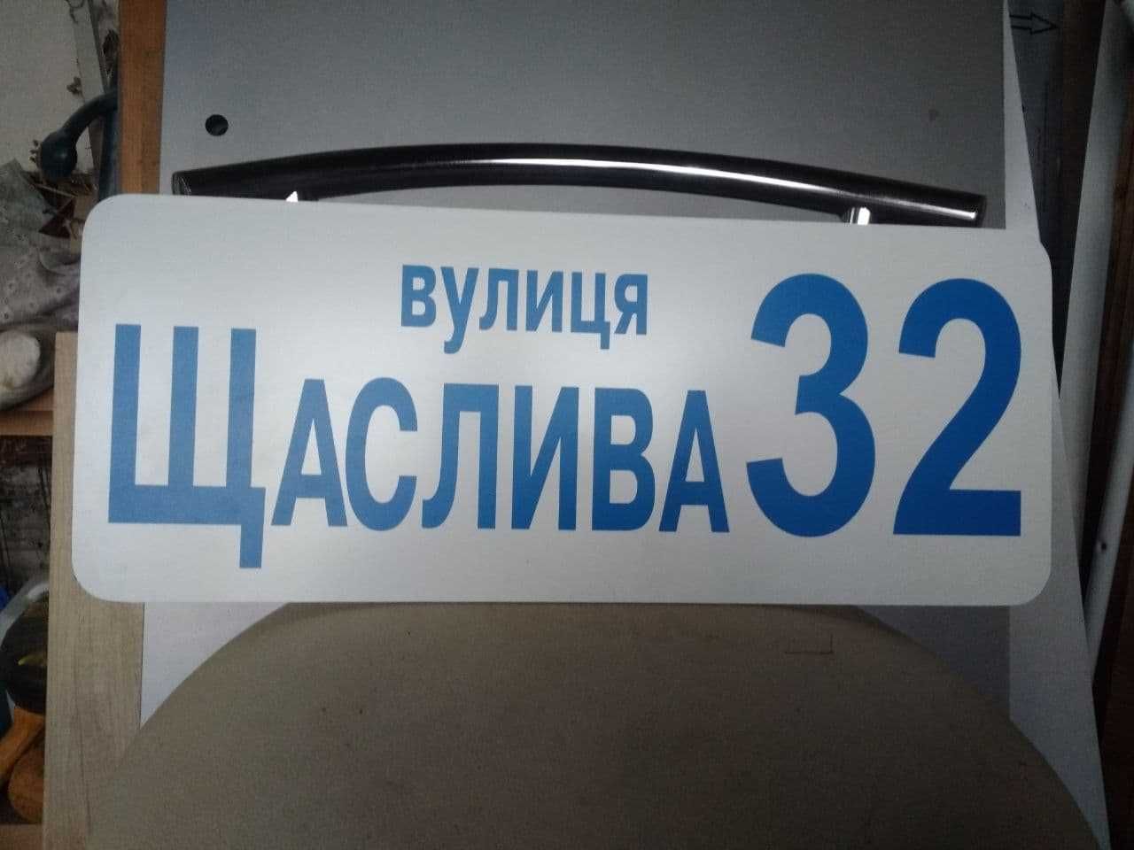 Адресна табличка з номером будинку і назвою вулиці