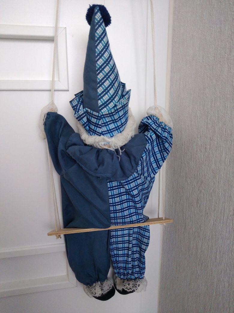 Klaun na huśtawce z porcelanową główką.