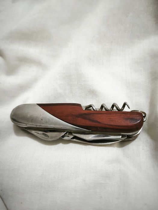 Canivete multifunções com acabamento em madeira e metal.