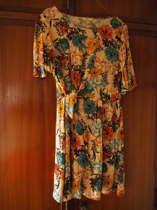 Vestido rosa pastel com padrão floral e nó lateral