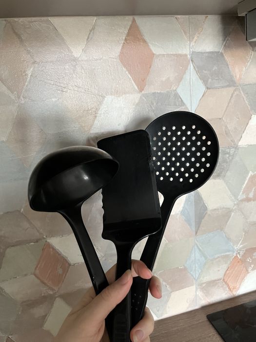 Czarne plastkikowe alcesoria kuchenne: chochla, cedzak, szpatuła