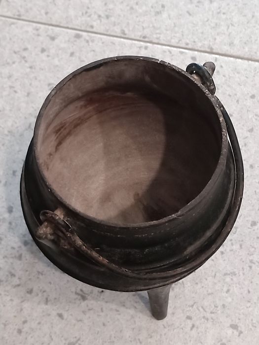 Panela de ferro forjado antiga para aquecer sobre a lenha