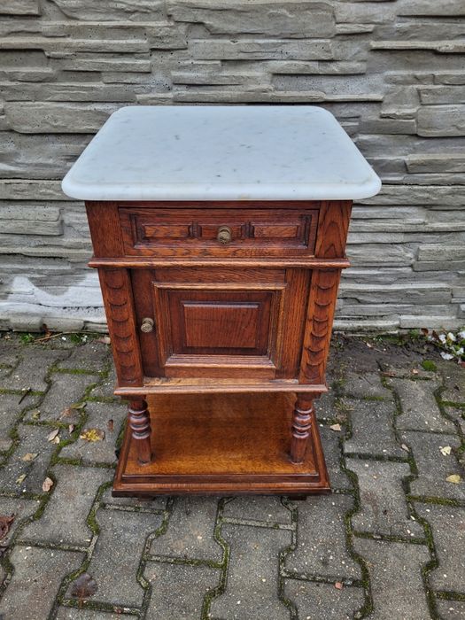 Zgrabna debowa szafka z szufladą.