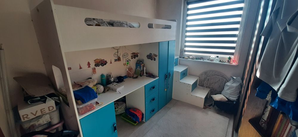 Łóżko piętrowe z biurkiem i schodami.