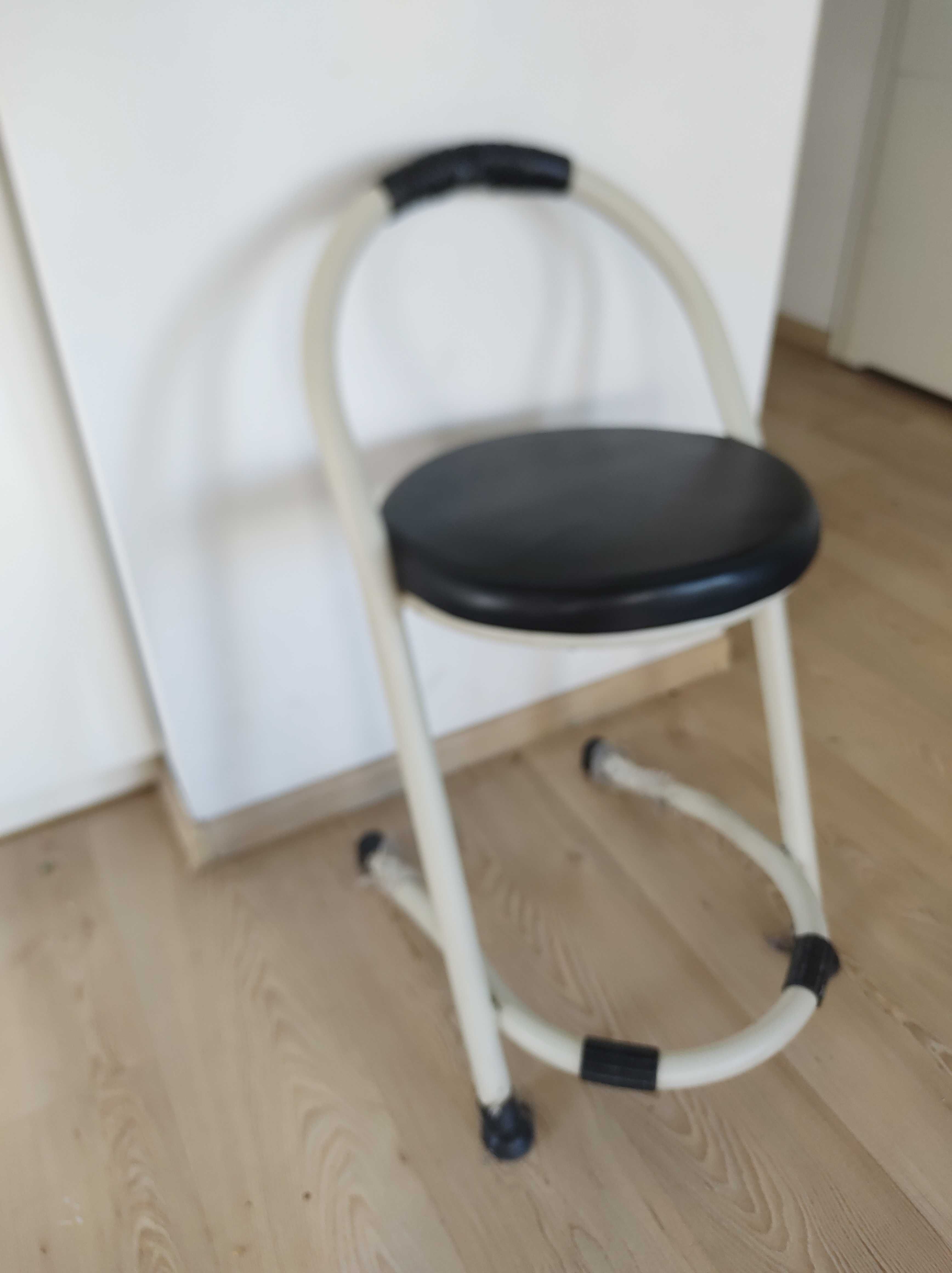 krzesełko do karmienia z białą metalową ramą i czarną poduszką