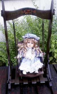 Zabytkowa lalka porcelanowa na huśtawce