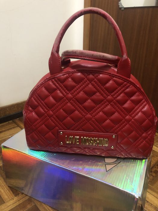 Mala moschino vermelha com corrente e dous bolsos interiores.