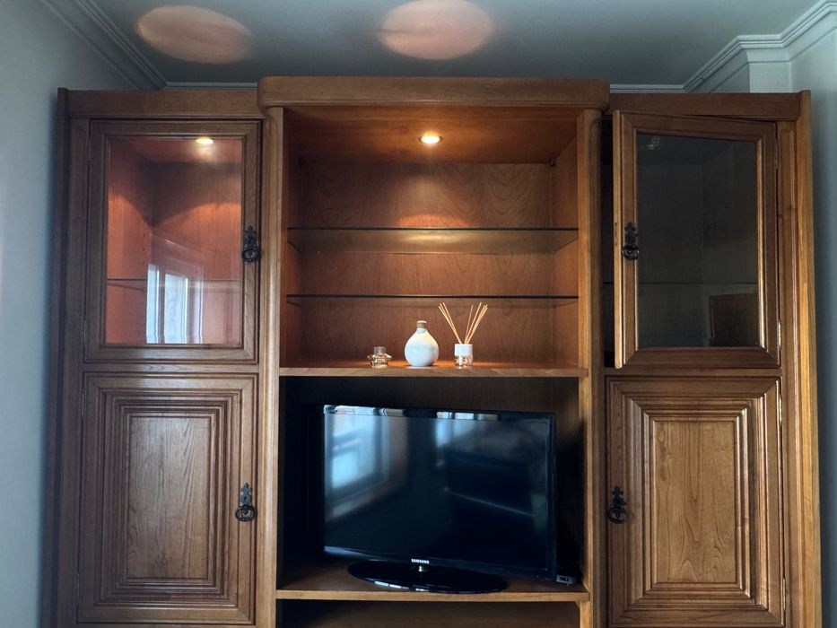 Móvel de sala grande em madeira escura com muita arrumação