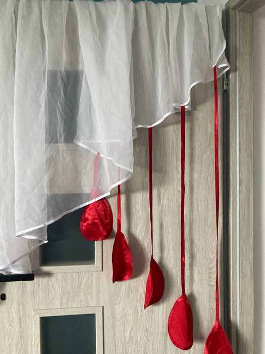 Nietuzinkowa firanka z czerwonymi ozdobami