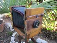 Máquina fotográfica muito antiga de madeira com fole