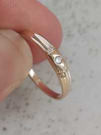 Złoty pierścionek z brylantem.