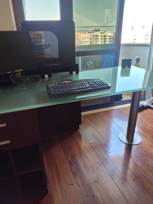 Secretária de vidro com gavetas em madeira.