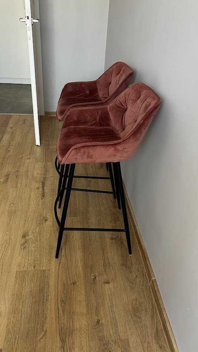 Dwa różowe tapicerowane hokery