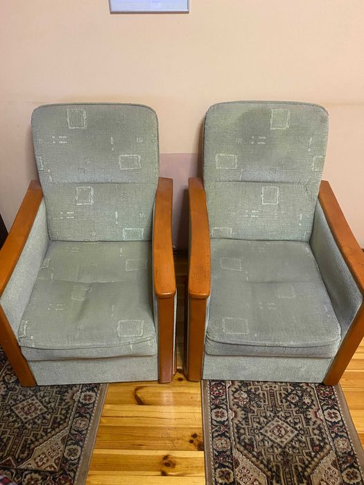 Dwa fotele z solidnej  zielonej tkaniny z drewnianymi podłokietnikami