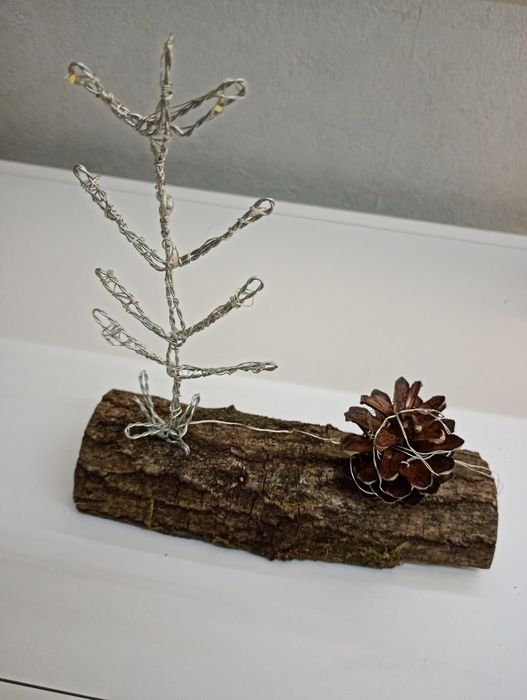 Troco de carvalho com pinha e árvore de Natal com luzes
