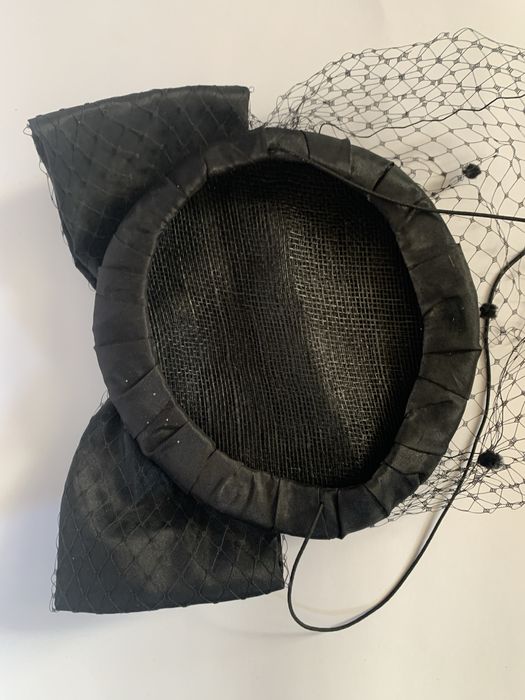 Чорний капелюшок-таблетка з вуаллю та бантом.