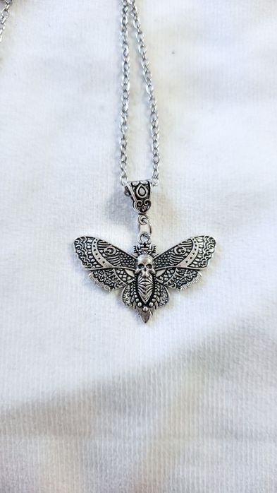 Na sprzedaż świetny naszyjnik w kolorze srebrnym ćma z czaszką. Posiad