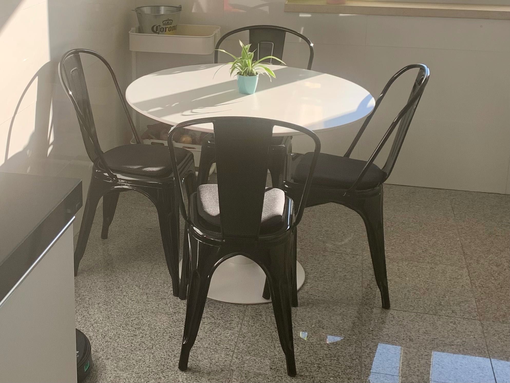 Mesa de cozinha redonda com 4 cadeiras (pretos) e 2 bancos (brancos)