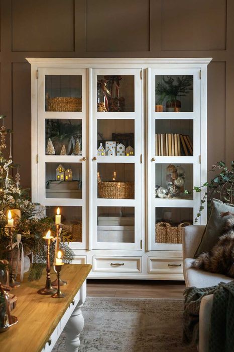 Biała witryna trzydrzwiowa na książki z szufladami do salonu