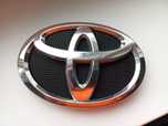Емблема бамперу переднього Toyota Corolla 2006-2013 75301-12390
