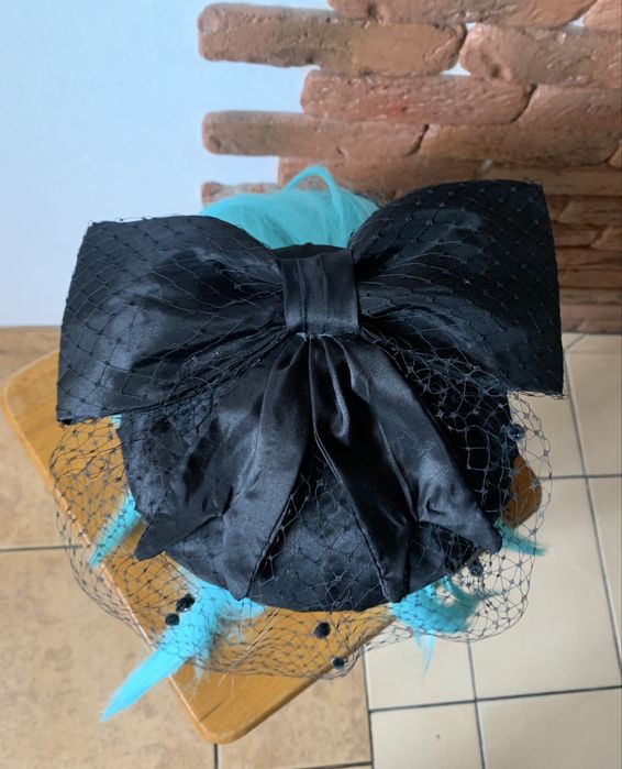 Чорний капелюшок-таблетка з вуаллю та бантом.