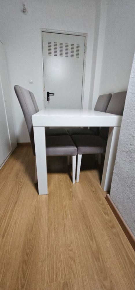 Mesa branca com 4 cadeiras cinzas