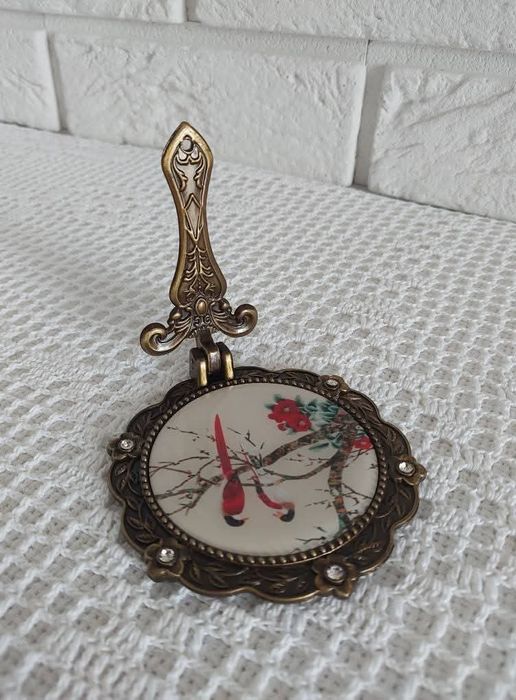 Lusterko z metalowej oprawie.