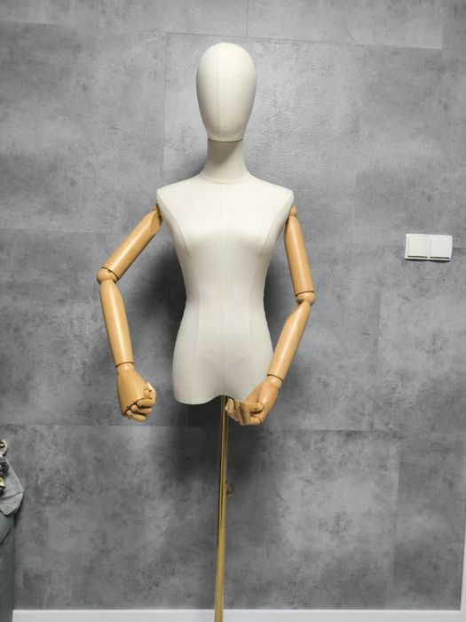 Manekin na złotej podstawie z ruchomymi rękami