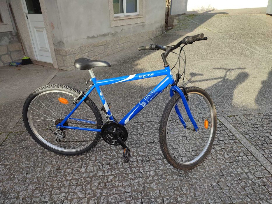 Bicicleta de montanha azul com mudanças e travões Shimano