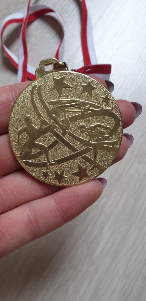 Medal w kolorze złotym na taśmie biało czarwonej