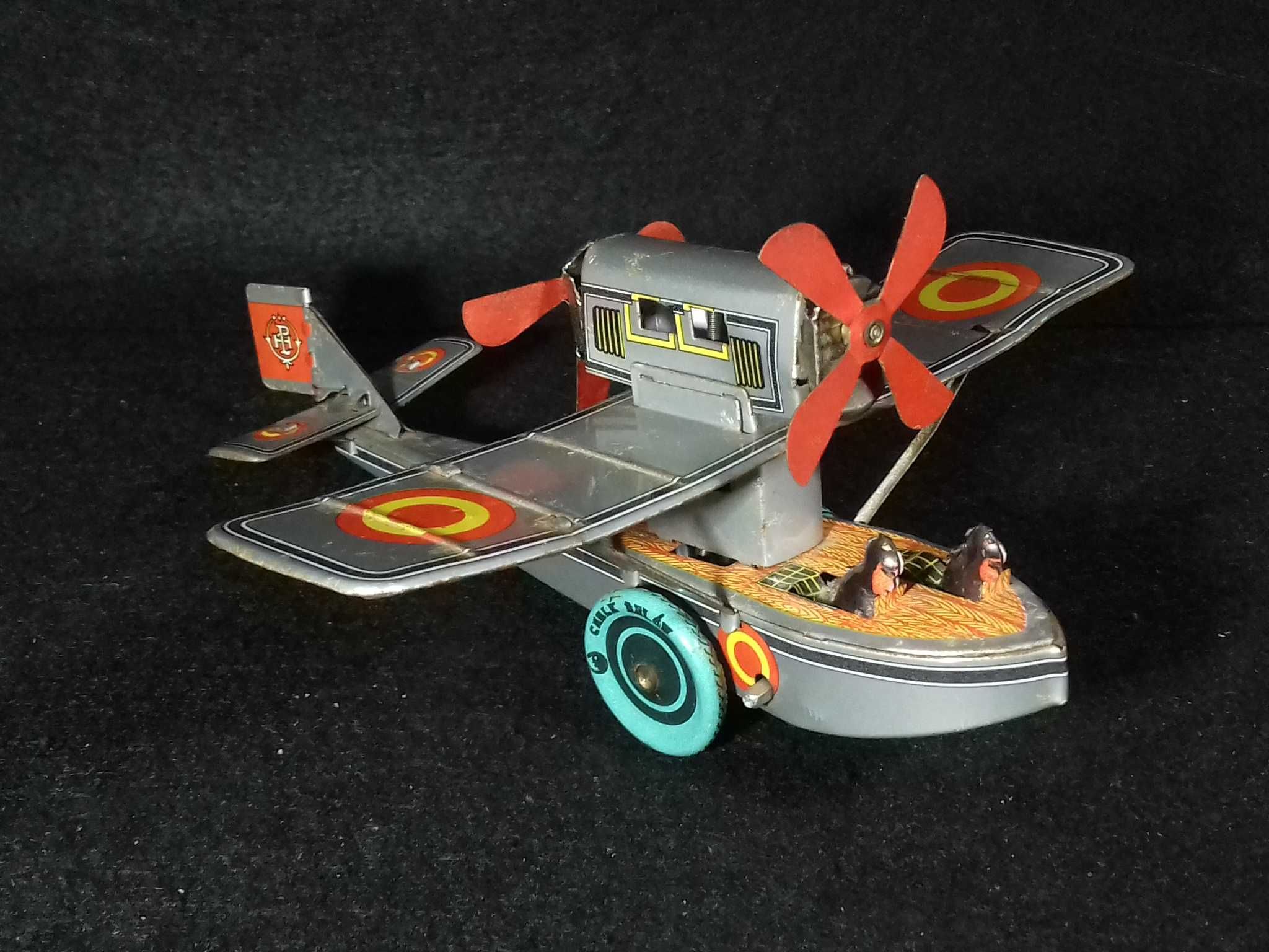 Miniatura de avião antigo em metal, com sistema mecânico de corda;