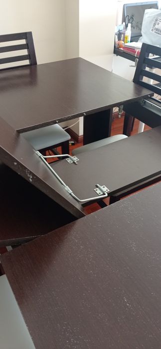 Mesa de madeira castanho escuro com seis cadeiras de pele