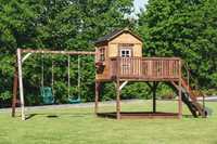 Drewniany domek ogrodowy dla dzieci z dużym podestem i huśtawką