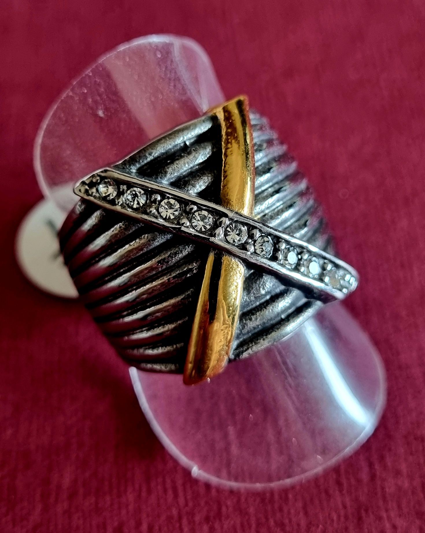 Anel prateado, em aço, com X dourado e com zirconias. T17/18