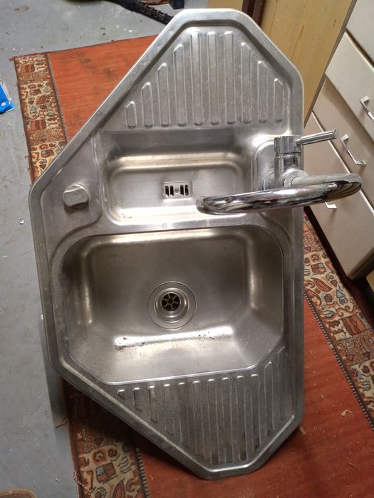 Zlewozmywak narożny stał nierdzewna z baterią i syfonem.