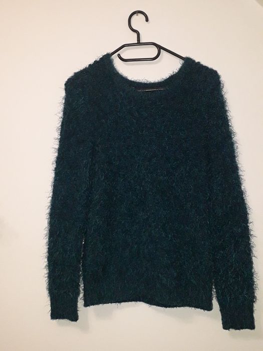 Puszysty sweter damski w morskim kolorze.