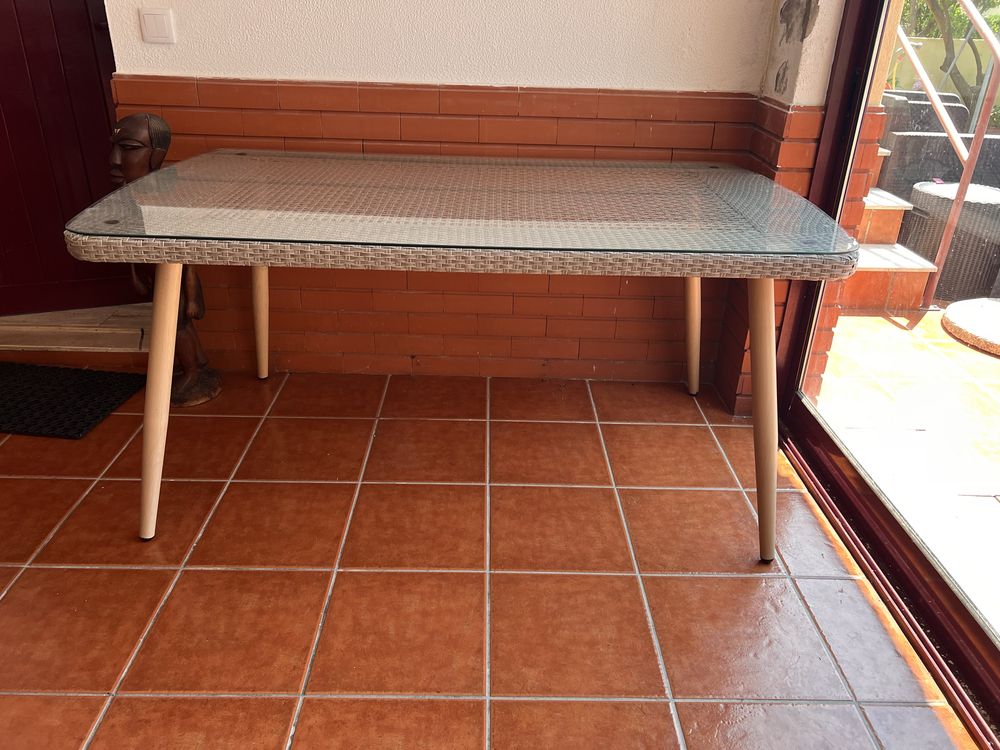 Mesa de exterior com tampo de vidro.