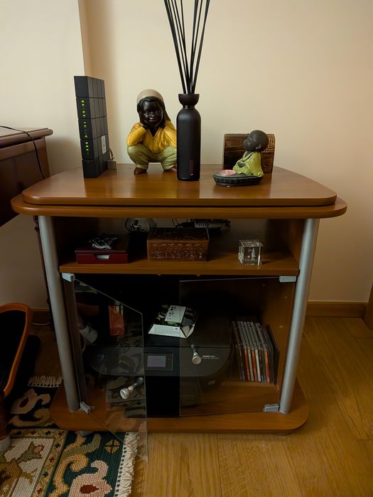 Móvel para TV em madeira tipo cerejeira e portas de vidro.