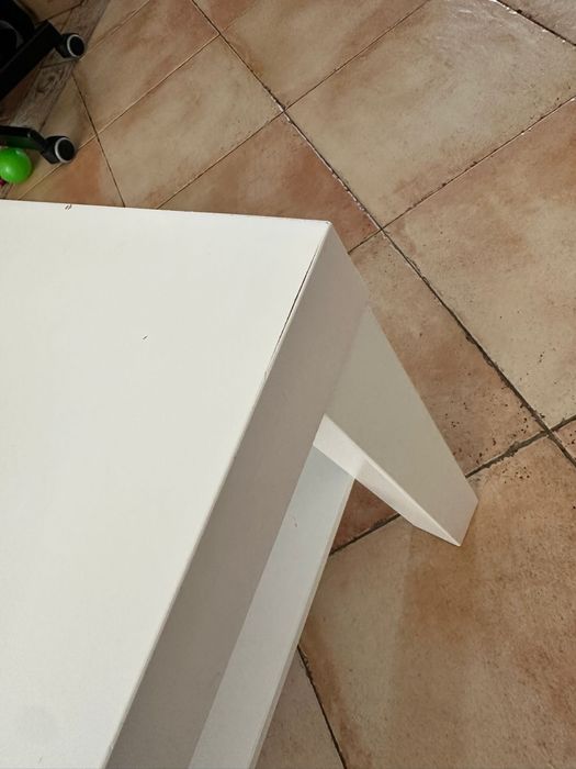 Mesa de centro branca, com uma prateleira inferior.
