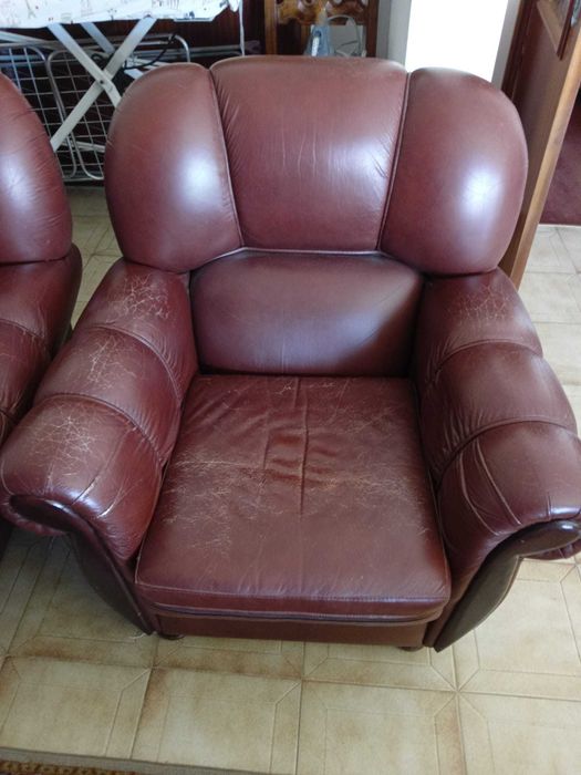 Sofá de três lugares e 2 poltronas em couro castanho.