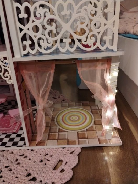 Drewniany domek dla lalek z mebelkami i światełkami