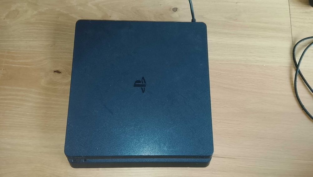 PS4 slim, com 2 comandos e 1 jogo